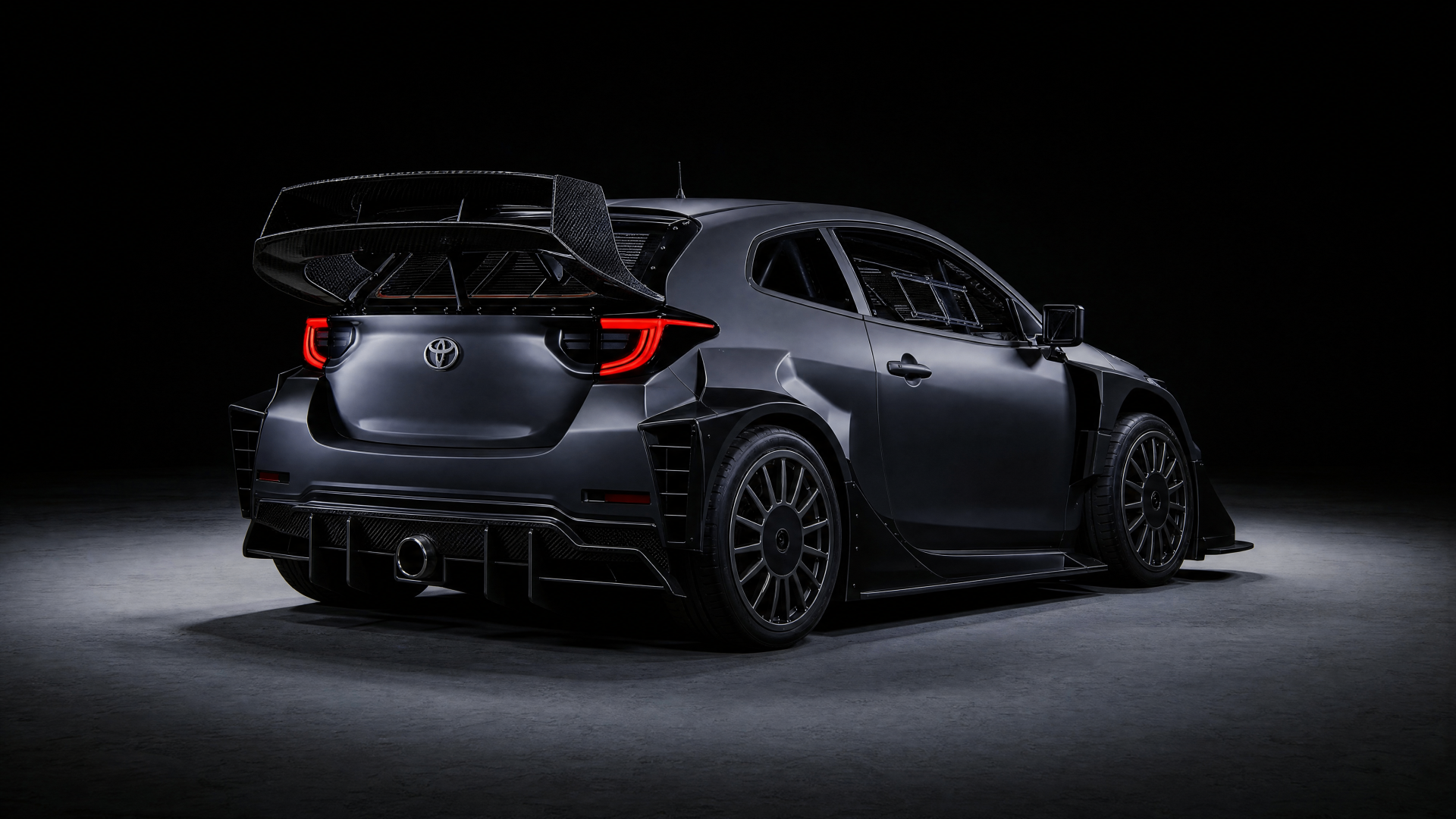 Toyota Yaris GR rally build — rear three-quarter view showing carbon wing and diffuser