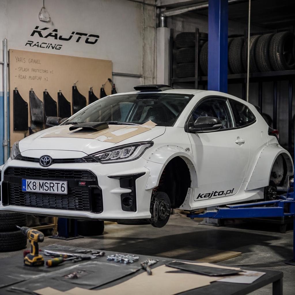 White Toyota Yaris GR in mid-build with rally-optimized fender flares